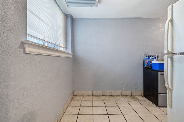 interior space featuring light tile patterned flooring and white refrigerator