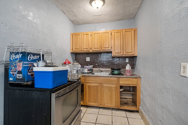 kitchen featuring backsplash, light tile patterned flooring, sink, and a textured ceiling