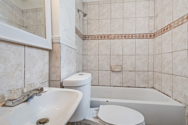 bathroom featuring sink, tile walls, and toilet