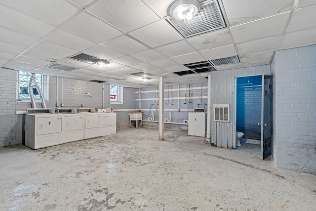 basement featuring washer and clothes dryer, a drop ceiling, and sink