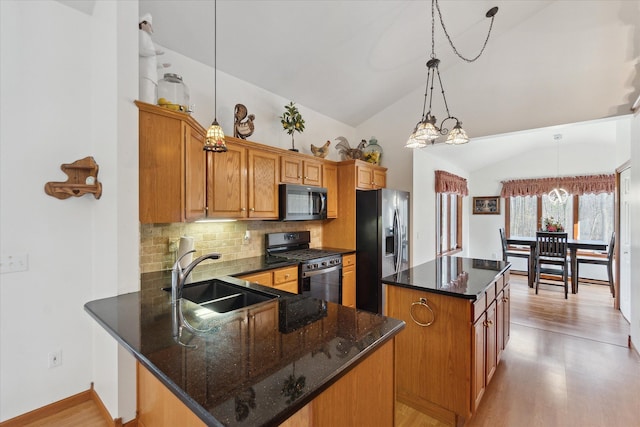 kitchen featuring a center island, sink, hanging light fixtures, stainless steel appliances, and vaulted ceiling