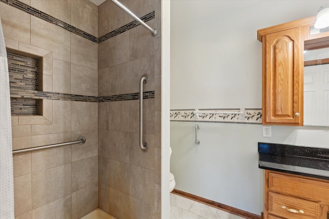 bathroom with a tile shower, tile patterned floors, vanity, and toilet