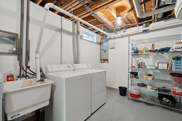 washroom featuring washing machine and dryer, sink, and electric panel