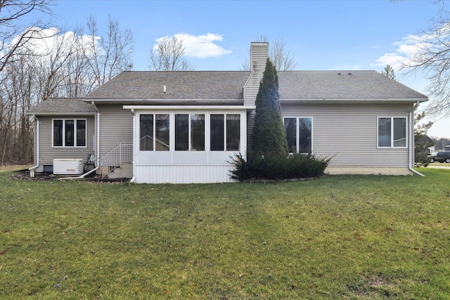 rear view of property with a sunroom and a yard