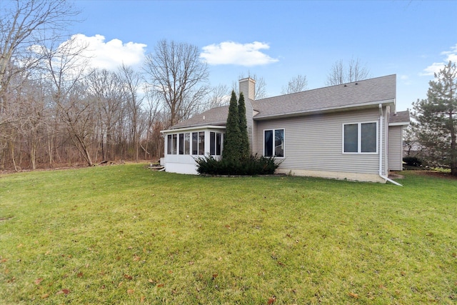 back of house with a lawn and a sunroom