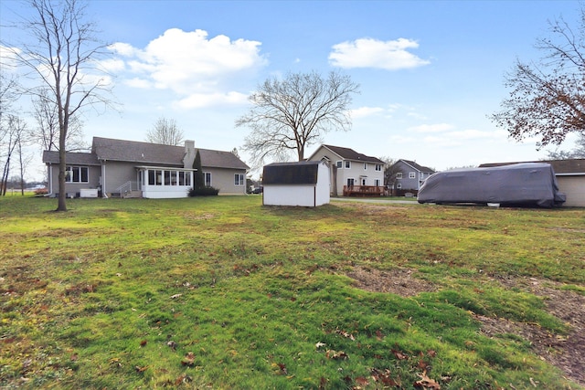 view of yard featuring a sunroom and a shed