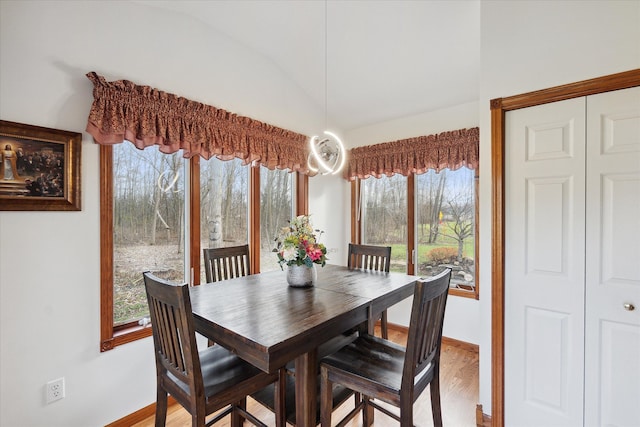 dining space featuring hardwood / wood-style flooring, plenty of natural light, and lofted ceiling