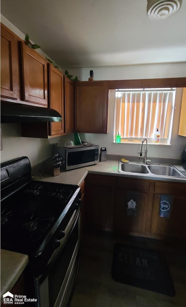 2273 Toby Beth Dr, Flint, MI 48505 - kitchen with stainless steel appliances, a sink, under cabinet range hood, brown cabinets, and light countertops