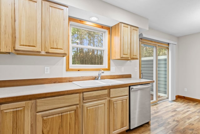 5279 Vinton Rd, Williamsburg, MI 49690 - kitchen with dishwasher, a sink, light brown cabinets, light wood-style flooring, and light countertops