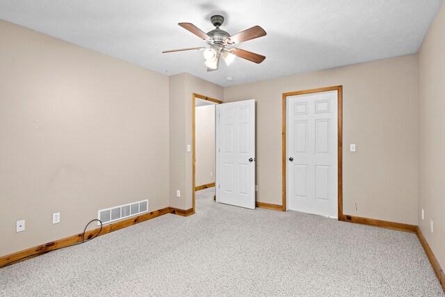 5279 Vinton Rd, Williamsburg, MI 49690 - unfurnished bedroom with baseboards, light carpet, and ceiling fan