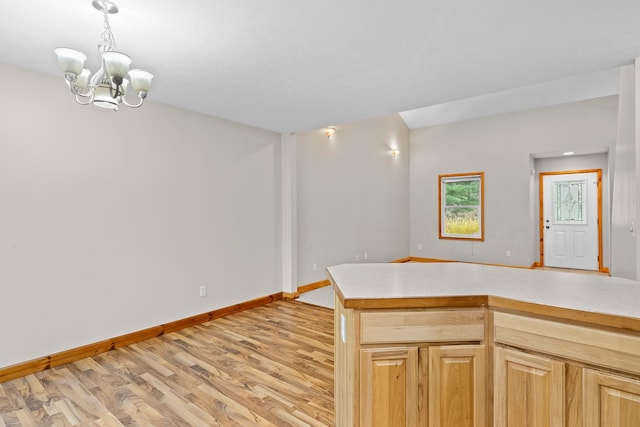 5279 Vinton Rd, Williamsburg, MI 49690 - kitchen with light wood-type flooring, baseboards, light countertops, and a chandelier