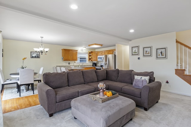 living room featuring light carpet, a notable chandelier, and sink