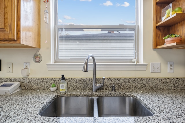 kitchen with light stone countertops and sink