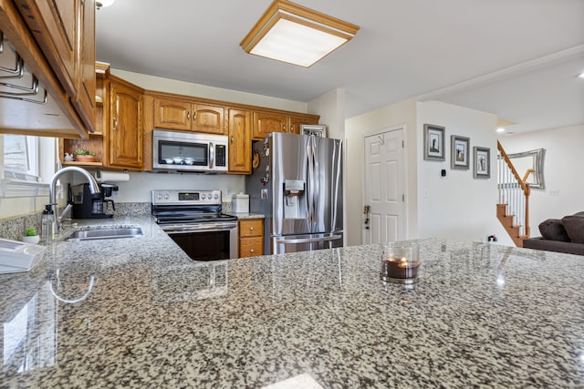 kitchen with sink, light stone countertops, and stainless steel appliances