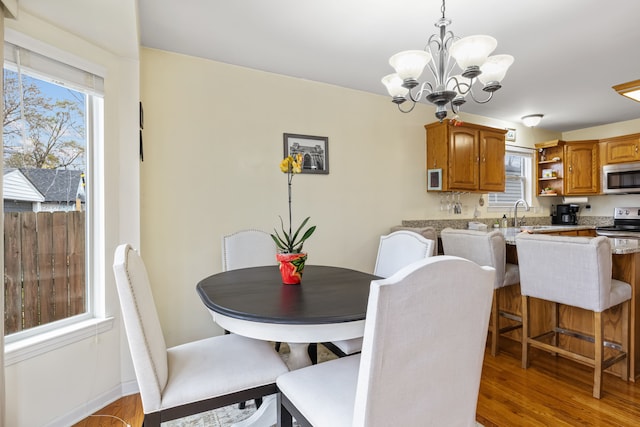 dining space featuring a chandelier, hardwood / wood-style floors, and sink