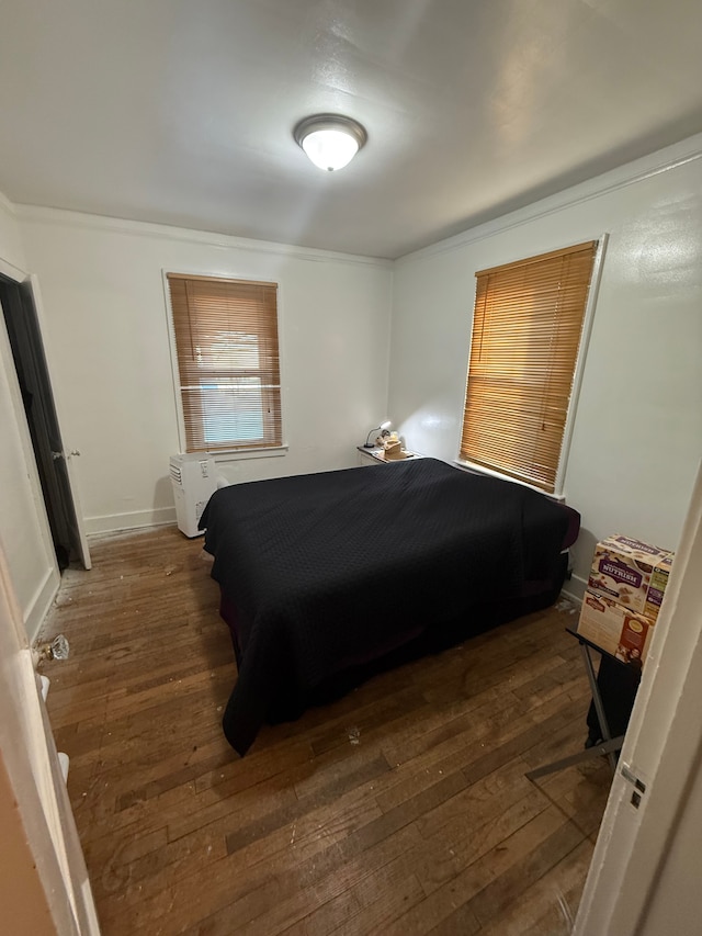 bedroom featuring crown molding and dark wood-type flooring