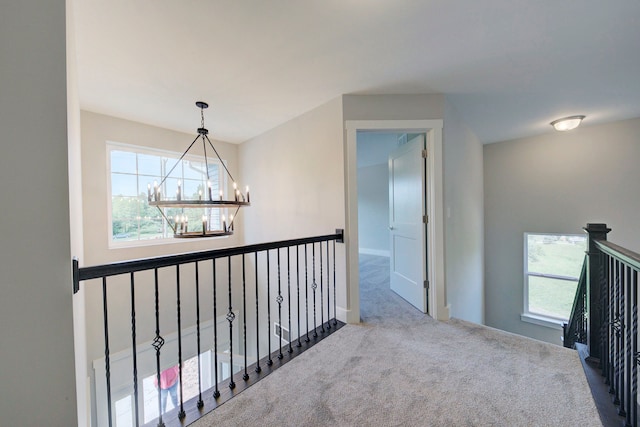 hallway featuring carpet floors and an inviting chandelier