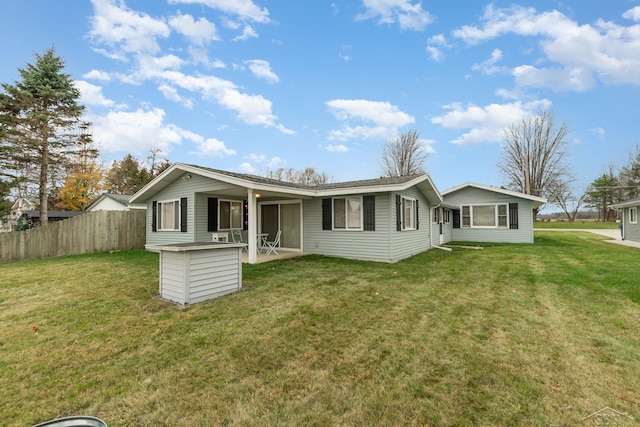 rear view of property featuring a lawn and a patio area