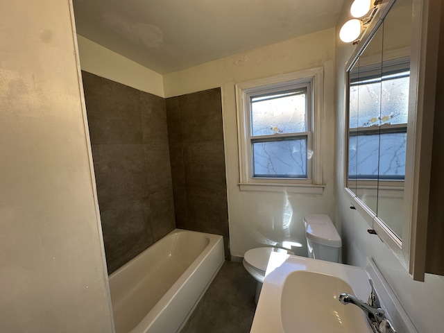 full bathroom featuring tile patterned floors, tiled shower / bath combo, toilet, and sink