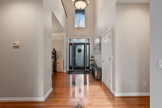 foyer entrance featuring light wood-type flooring and a high ceiling