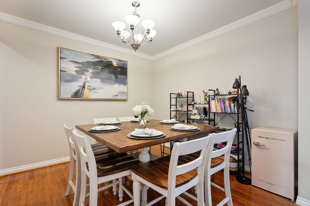 dining area with ornamental molding, a chandelier, and hardwood / wood-style flooring