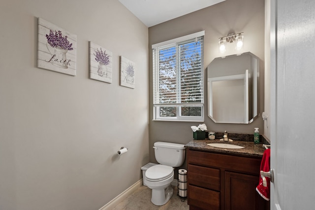 bathroom with tile patterned flooring, vanity, and toilet