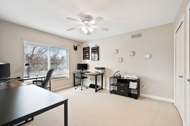 carpeted office space featuring ceiling fan