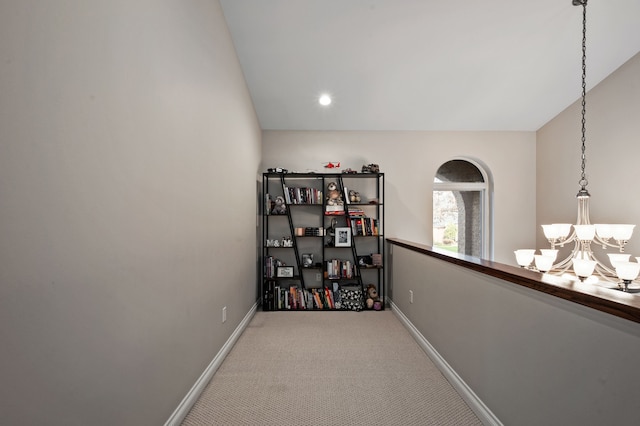 corridor with carpet, a chandelier, and lofted ceiling