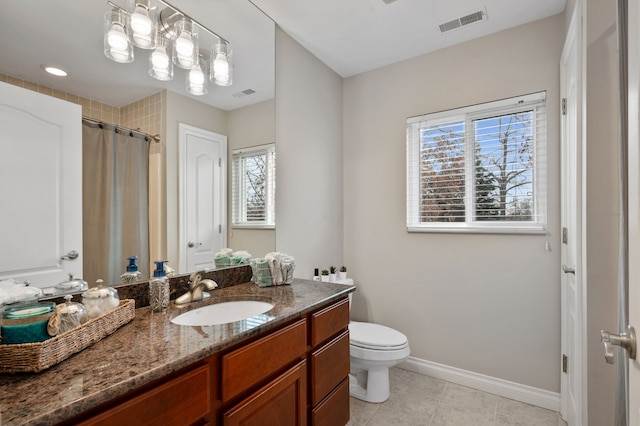 bathroom featuring tile patterned flooring, plenty of natural light, toilet, and vanity