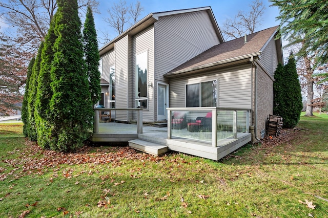 rear view of property featuring a deck and a yard