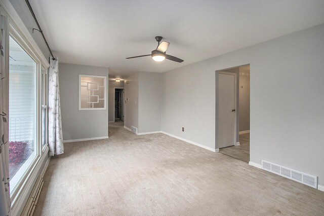 spare room featuring light carpet and ceiling fan