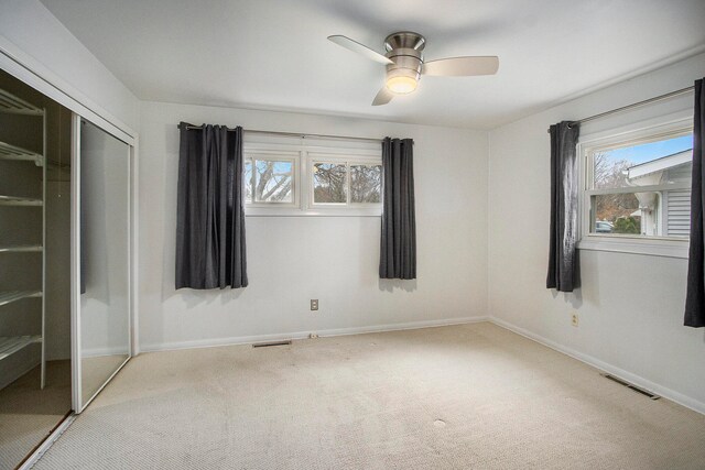 unfurnished bedroom with a closet, ceiling fan, and light colored carpet