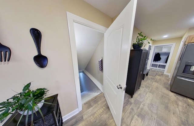 hallway with light wood-style flooring and baseboards
