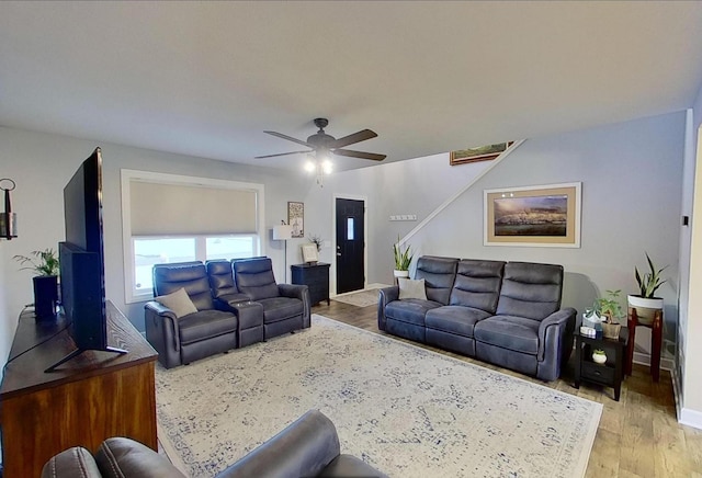 living room with ceiling fan, stairs, wood finished floors, and baseboards