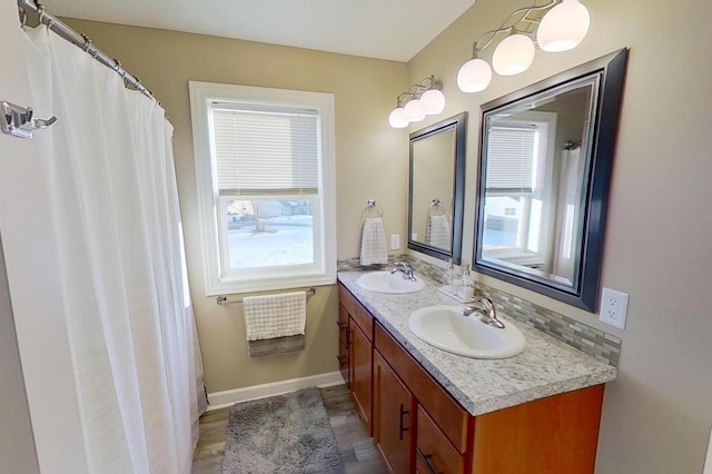 full bathroom with a sink, baseboards, and a wealth of natural light