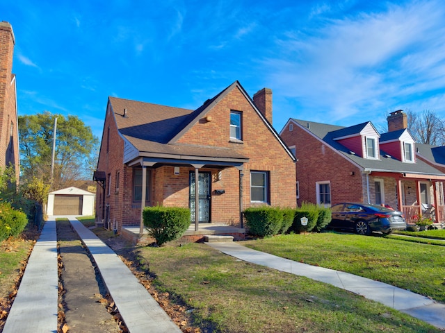 view of front of house with a garage, an outbuilding, and a front yard