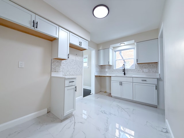 kitchen featuring white cabinets, decorative backsplash, and sink