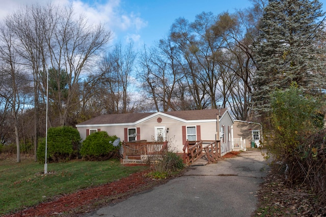 view of front of house with a deck and a front lawn