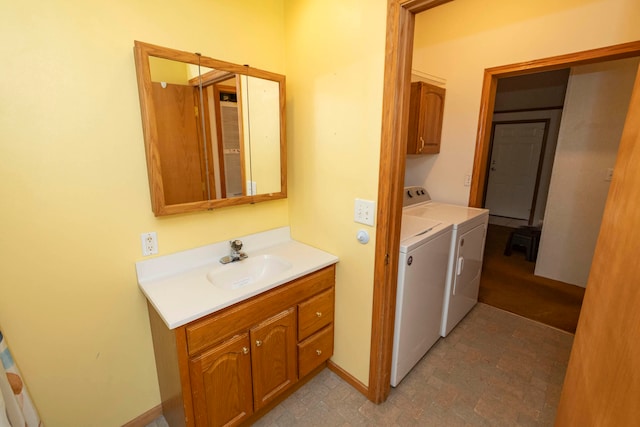 laundry area featuring cabinets, washing machine and dryer, and sink