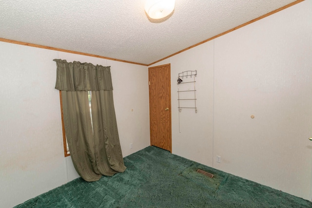 carpeted spare room with vaulted ceiling, a textured ceiling, and ornamental molding