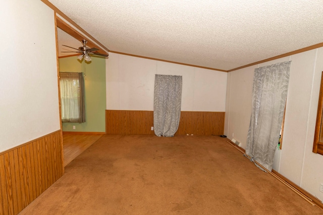 spare room with vaulted ceiling, ceiling fan, carpet, and a textured ceiling