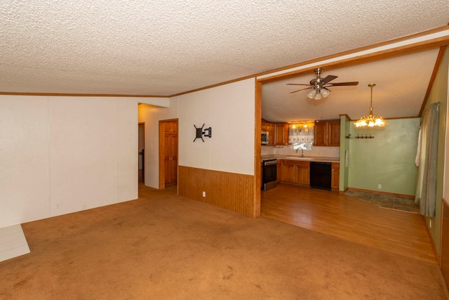 unfurnished living room featuring sink, ceiling fan, ornamental molding, a textured ceiling, and light hardwood / wood-style floors