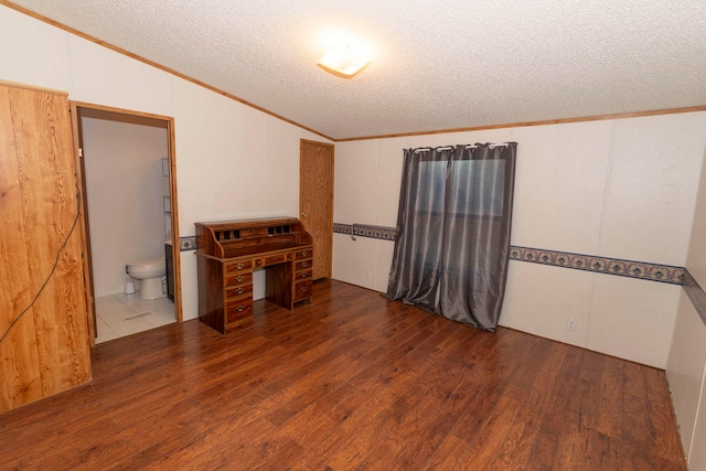 empty room featuring dark hardwood / wood-style floors, crown molding, lofted ceiling, and a textured ceiling