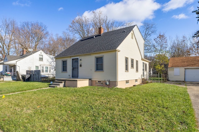 view of front of house featuring an outbuilding, a front lawn, and a garage