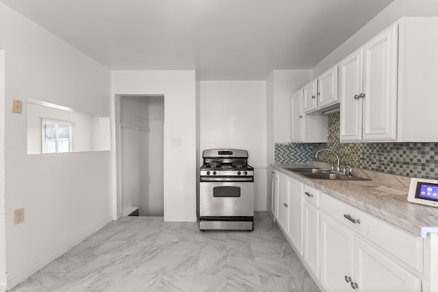 kitchen with decorative backsplash, sink, white cabinets, and stainless steel range with gas stovetop