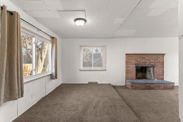 unfurnished living room featuring carpet flooring and a brick fireplace