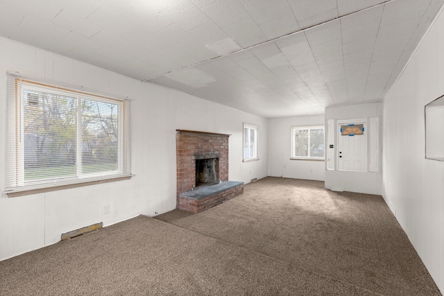 unfurnished living room featuring carpet flooring and a fireplace