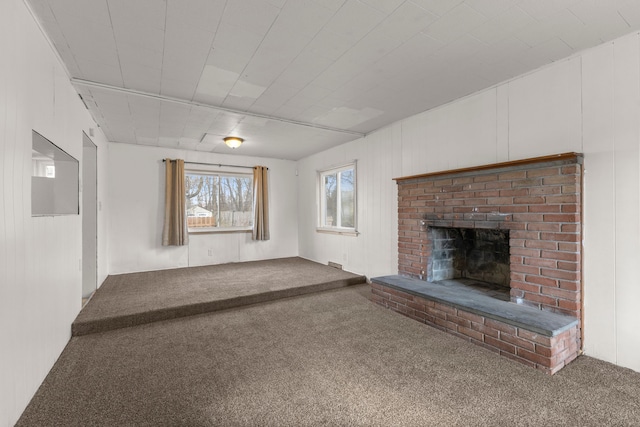 unfurnished living room with carpet flooring and a brick fireplace