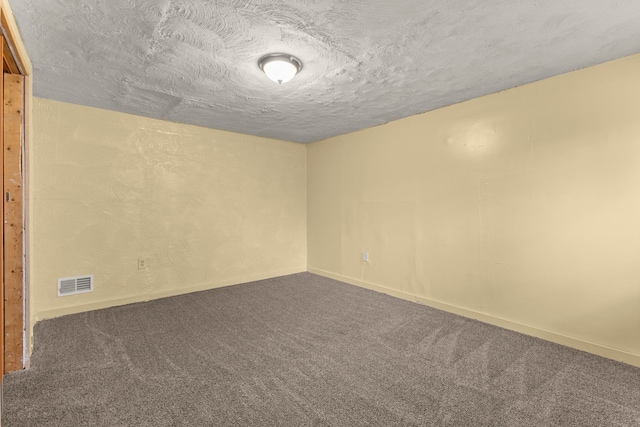 empty room featuring carpet and a textured ceiling