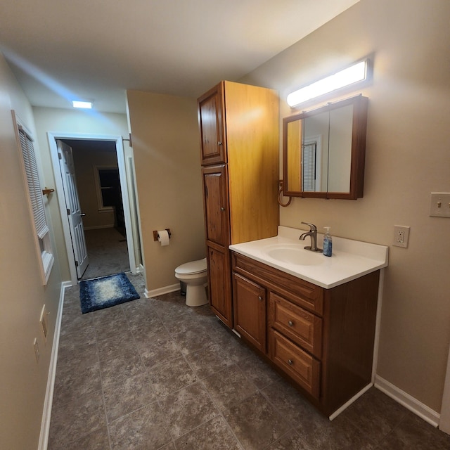 8789 Fowlerville Rd, Fowlerville, MI 48836 - bathroom featuring vanity, toilet, and baseboards